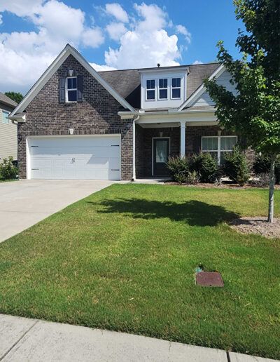 A home, specifically its lawn, after it has been serviced by Absolute Green Landscaping, now weed free and healthy